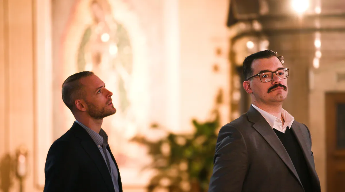 Two guests in conversation inside a church